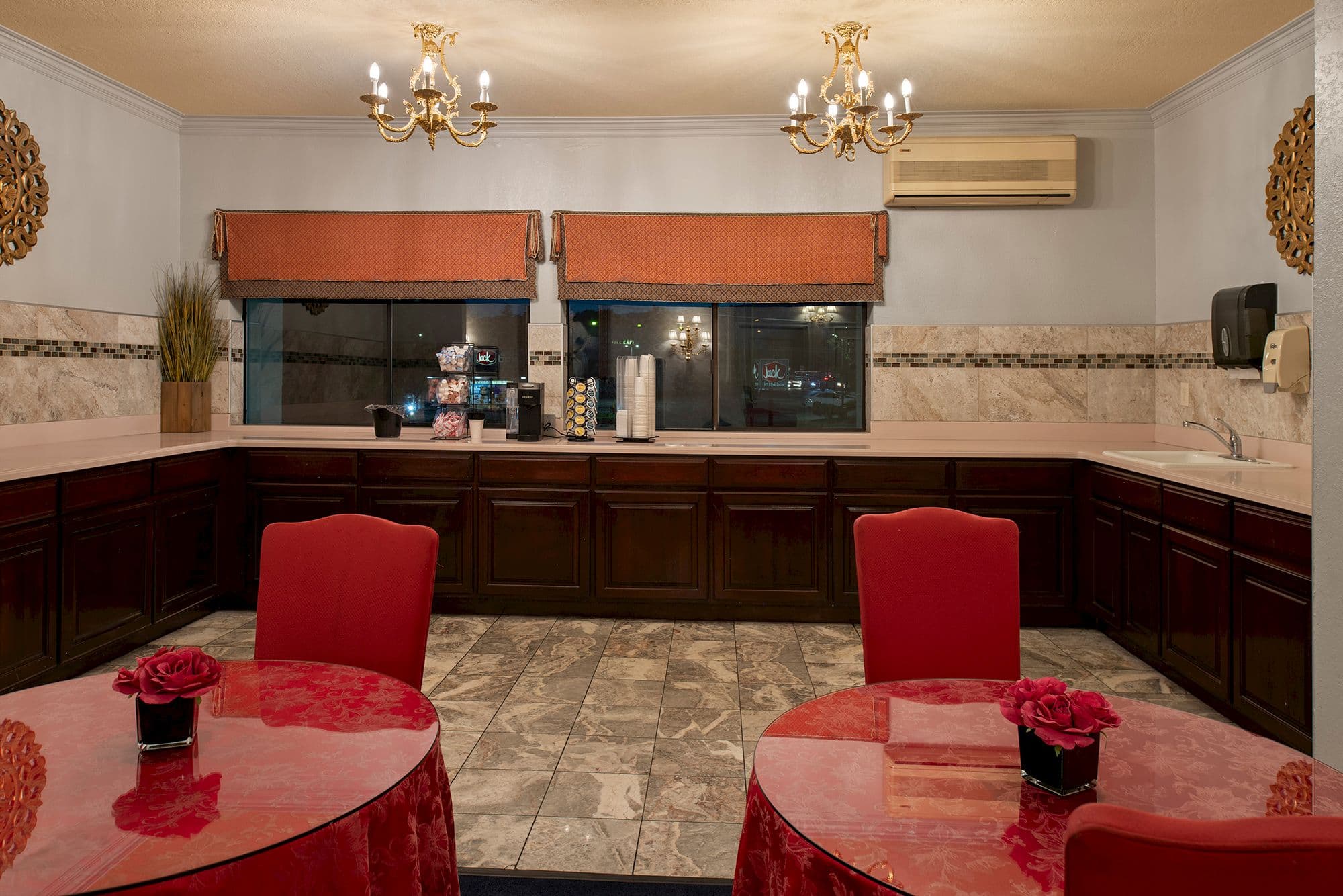 Coffee room with red-draped tables, gold chandeliers and a coffee station