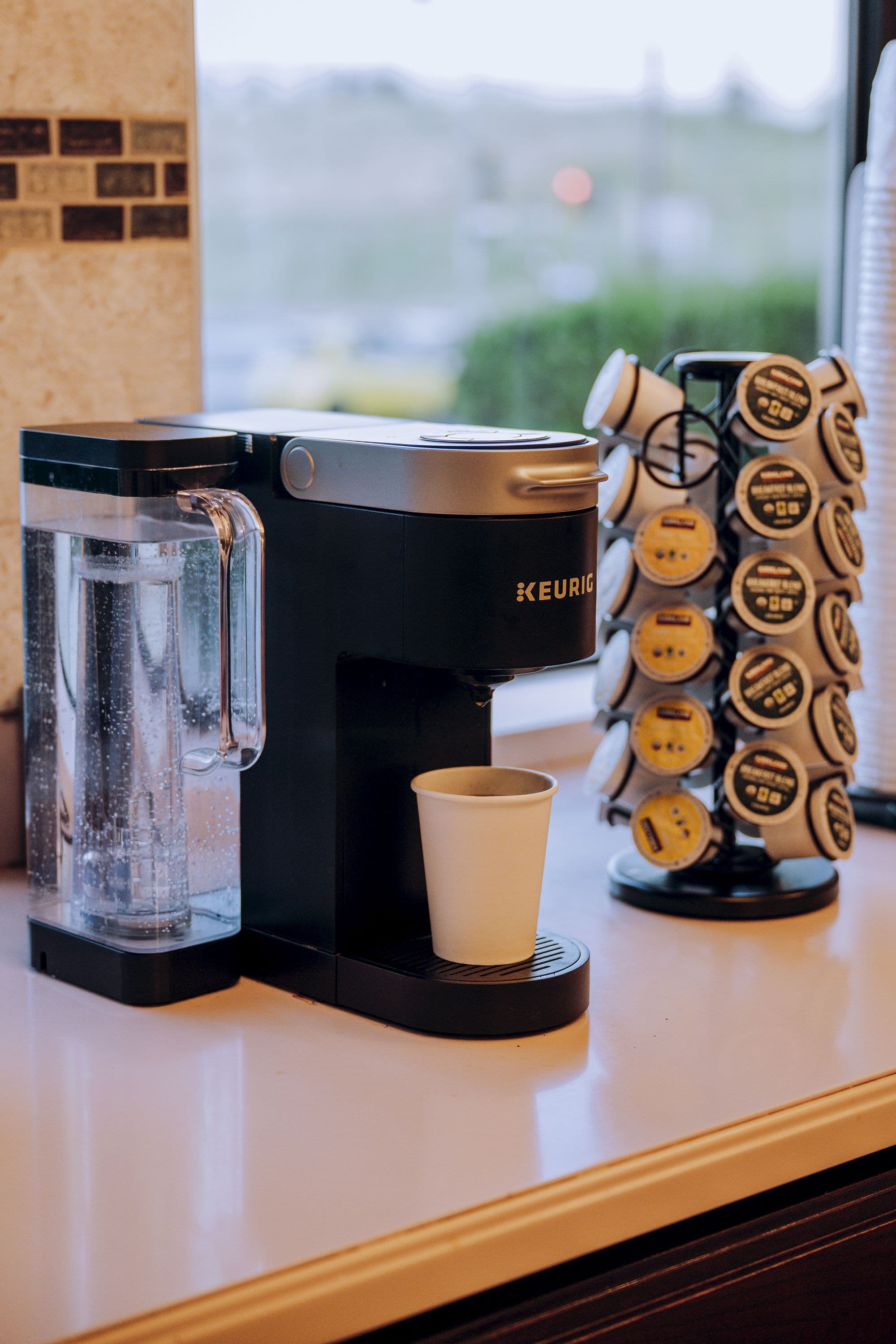 Keurig coffee maker with a paper cup and a carousel of coffee pods