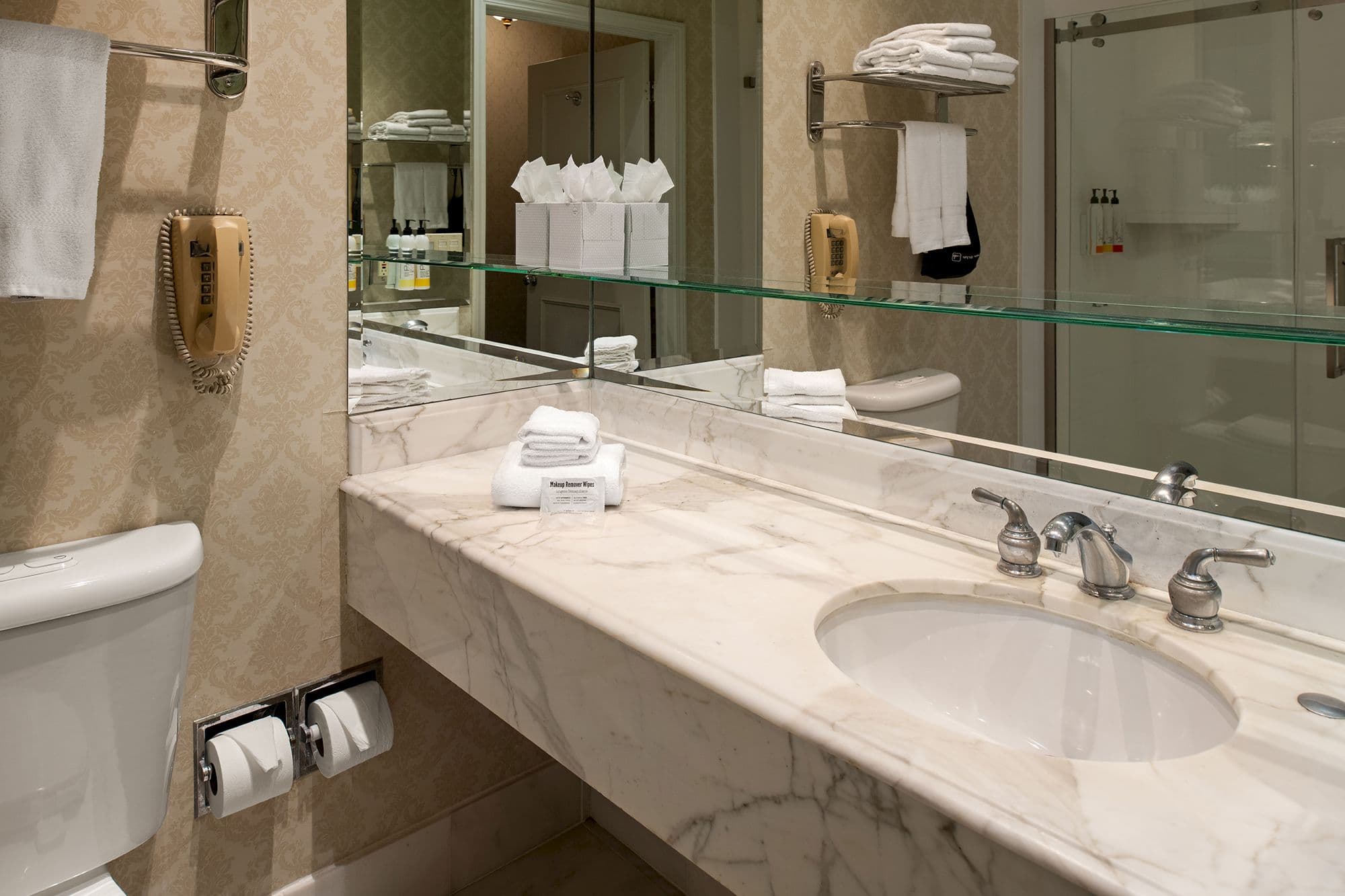 Marble bathroom vanity with a wide mirror and fresh towels