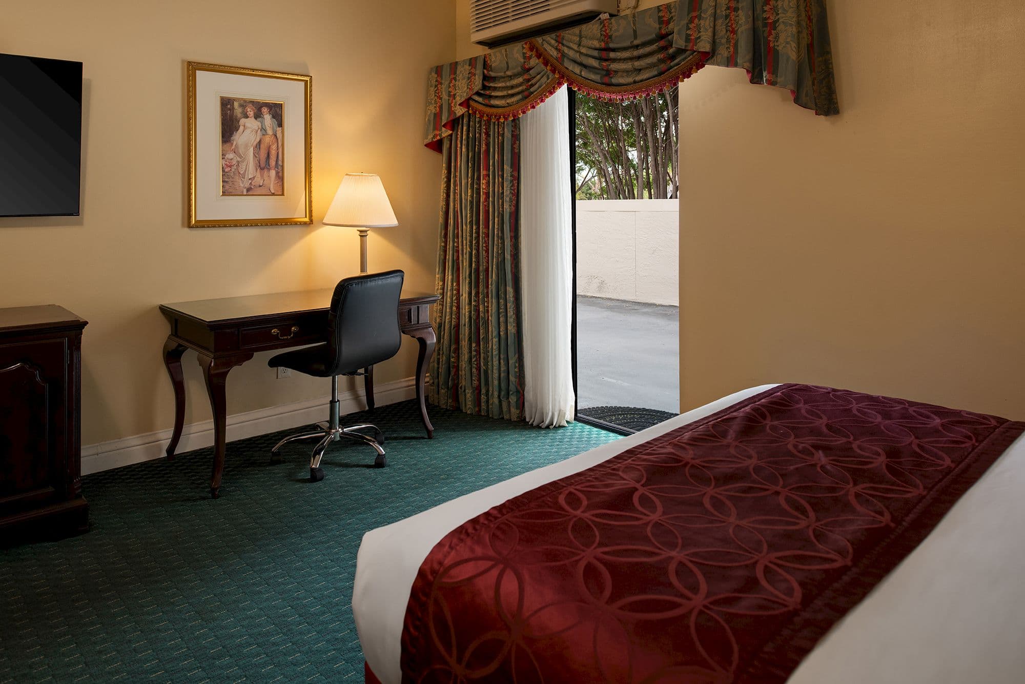 Guest room with a desk and an open sliding door to an outdoor patio